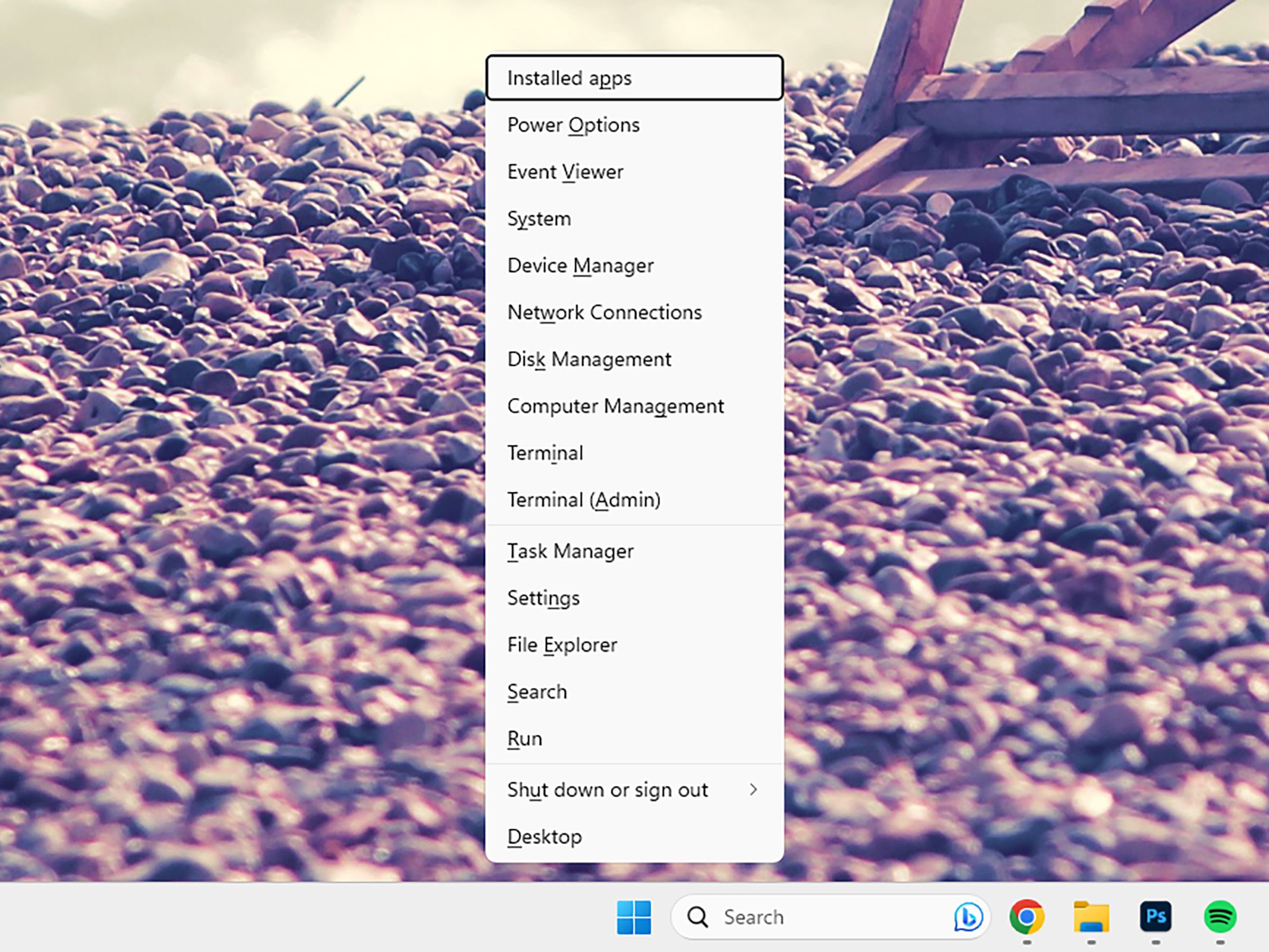 Windows 11 screen with background of rocky beach and long menu in the center with various operating system acctions.