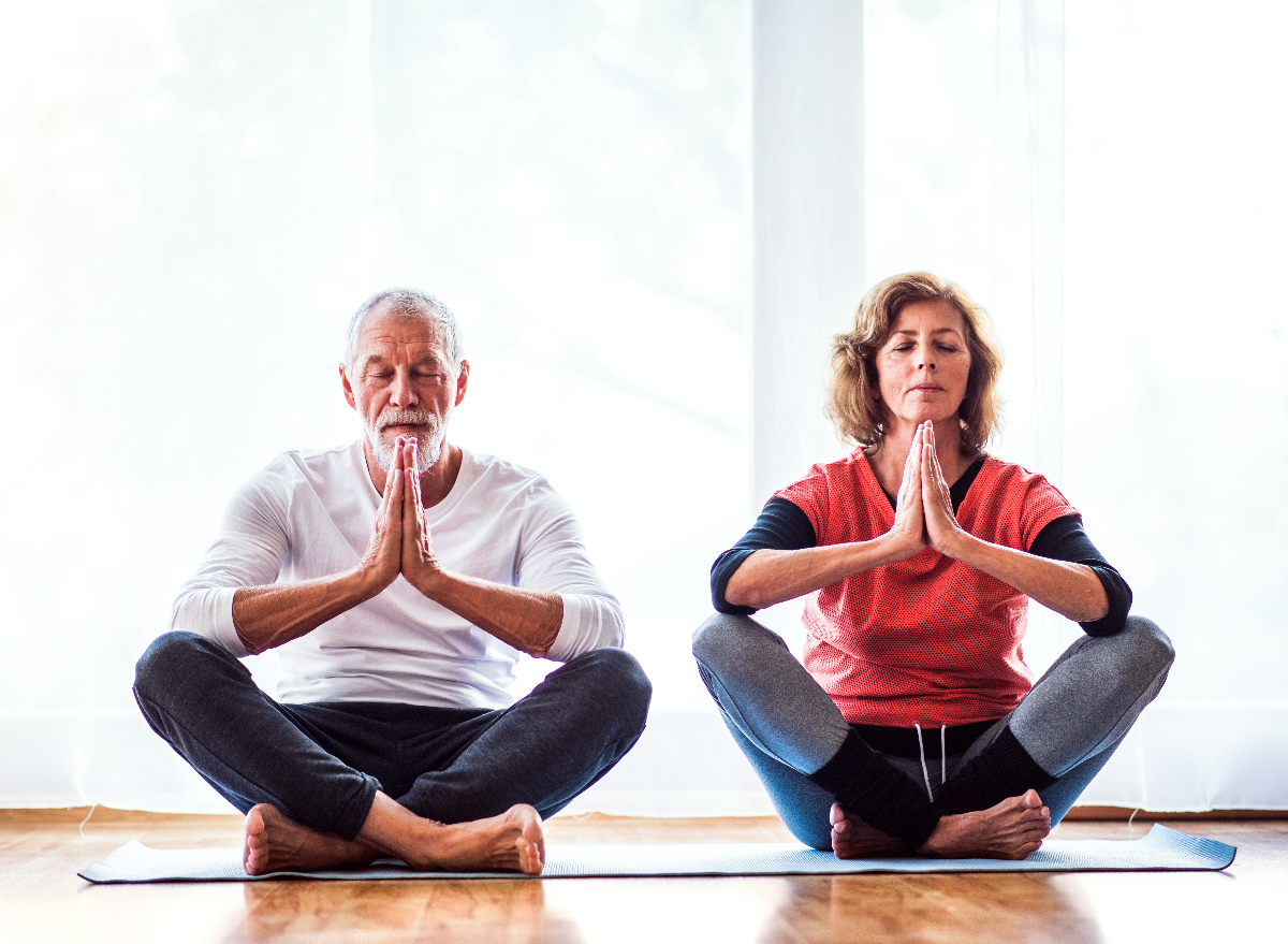 mature couple meditating at home