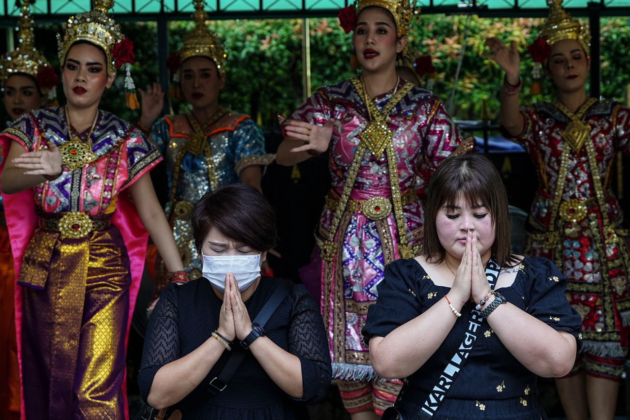 Chinese tourists pray in front of Thai dancers at the Erawan Shrine in Bangkok, Thailand on September 22, 2023. 