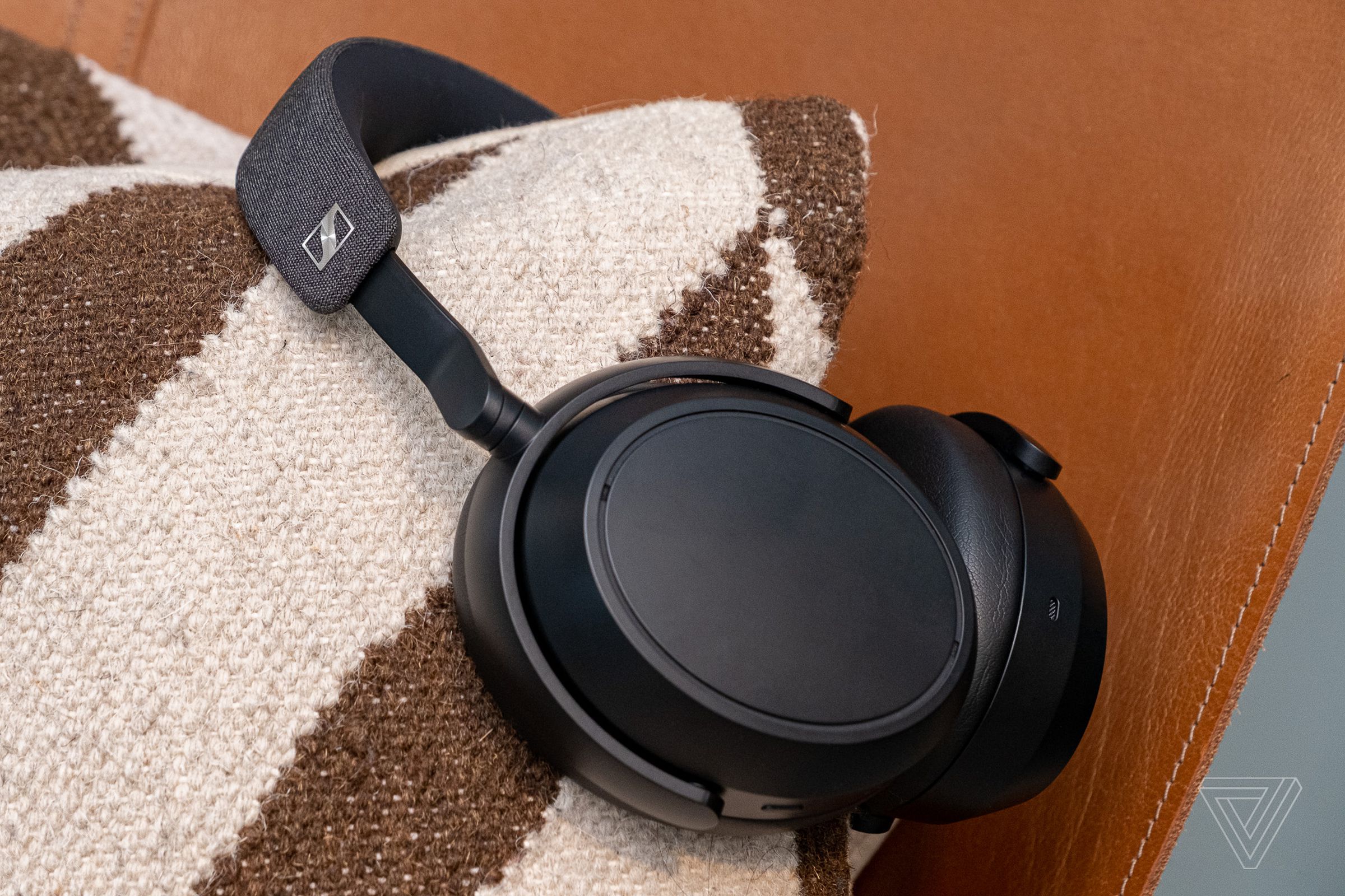 A photo of Sennheiser’s Momentum 4 headphones on a pillow.