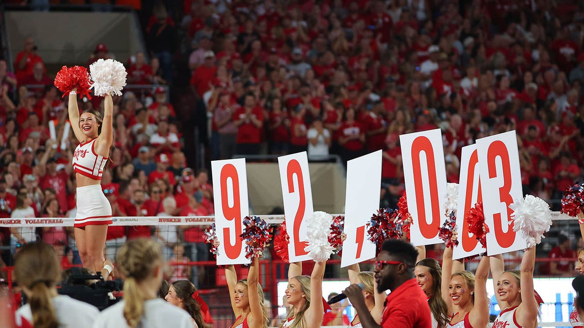 Cheerleaders hold up signs