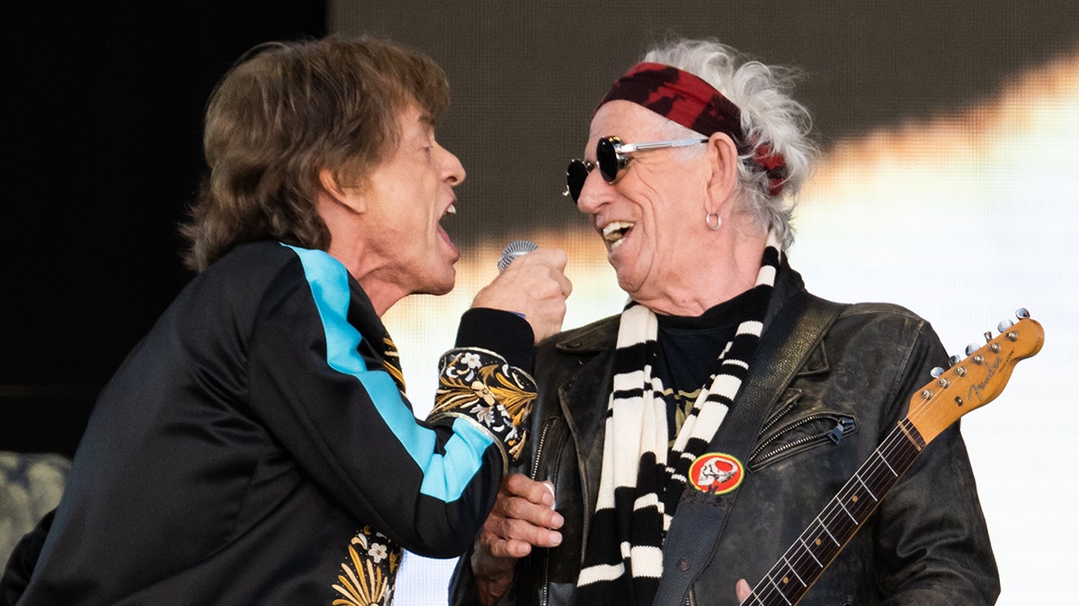 Mick Jagger and Keith Richards sing into a microphone together