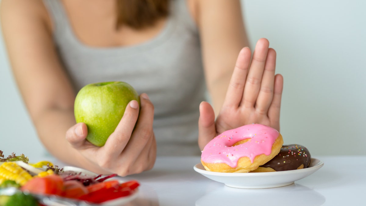 Woman with apple and donuts