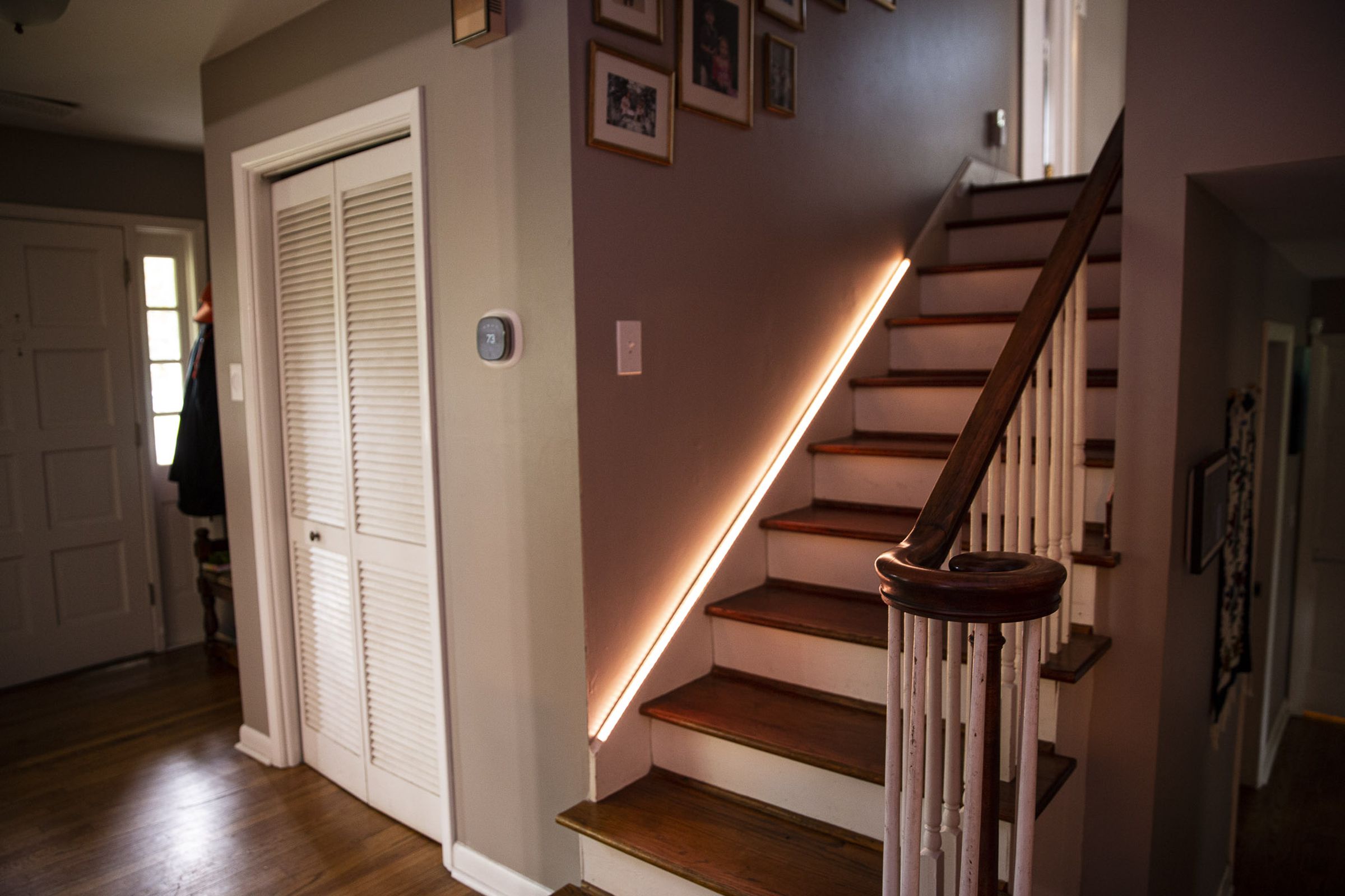 Govee’s LED Strip Light M1 Matter hanging on a staircase railing while raiding white light.