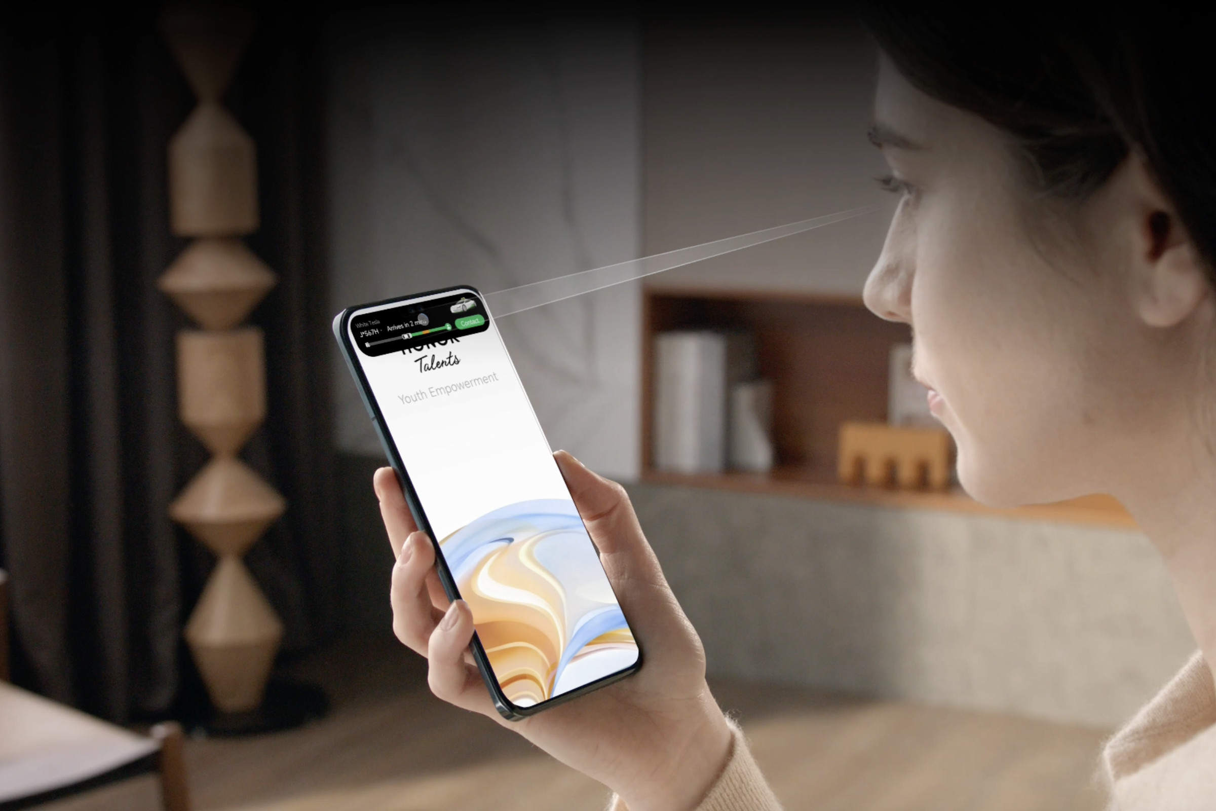 Image of a woman gazing at phone screen with Uber app in a pill-shaped notch.