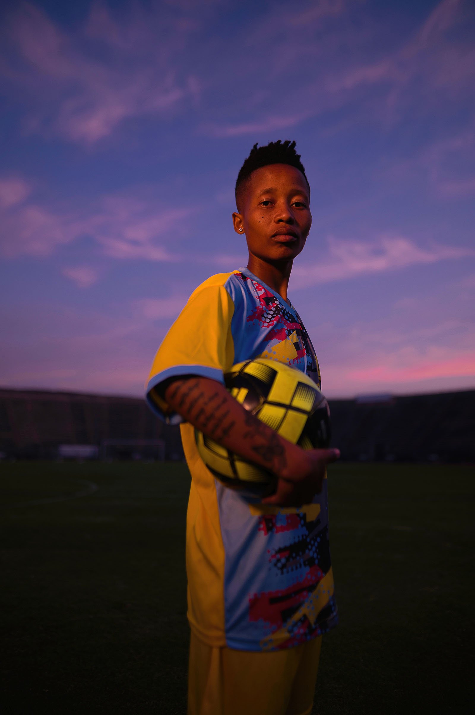 A man stands as the sky turns dark in the background.