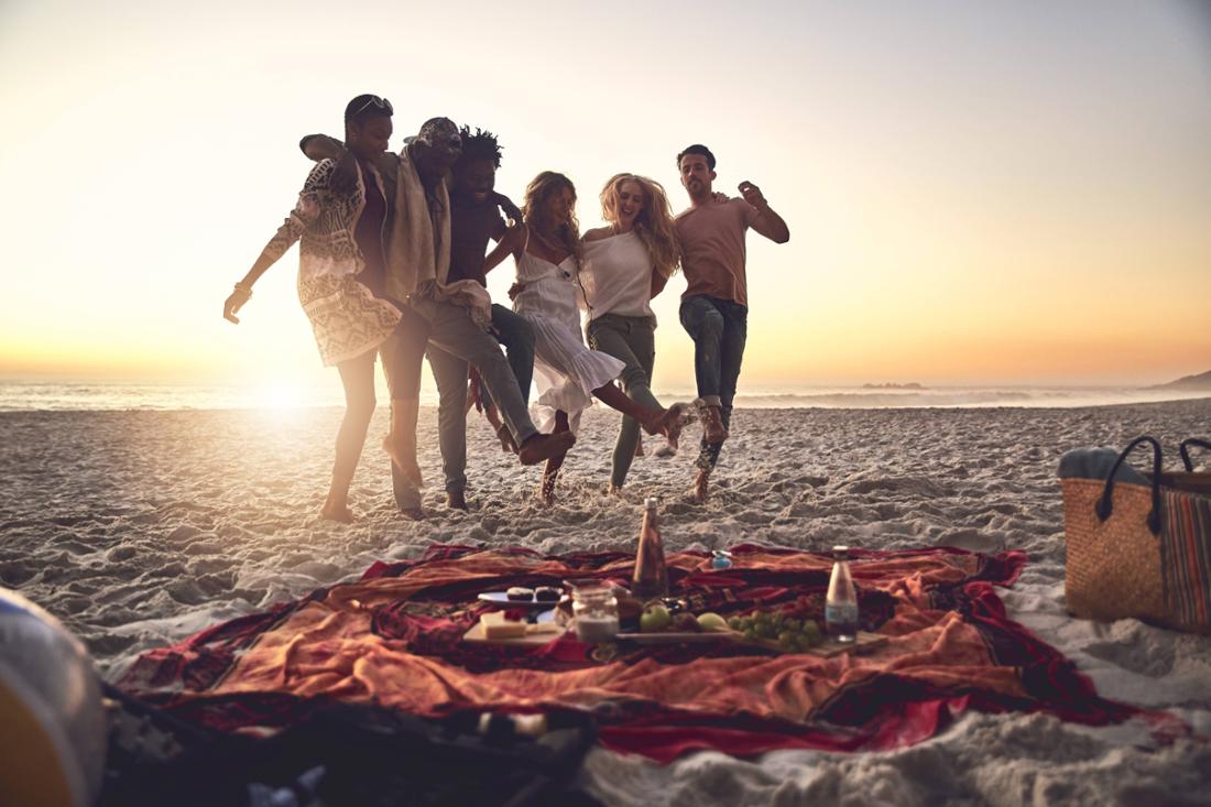 Mehrere Freunde machen Picknick am Strand.