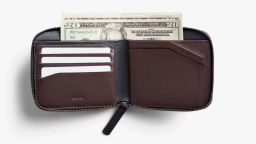 Bellroy's Zip Wallet. It's open, with American notes poking out of the note pocket up the top. Three white example cards are in the card pocket on the left, while the coin pouch is on the right.