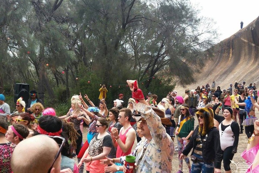 crowd dancing under rock 