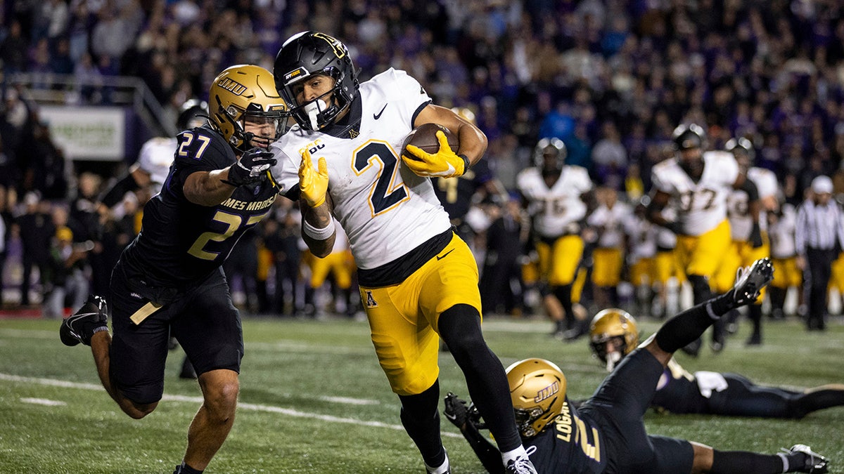 Appalachian State player attempts to outrun a James Madison player