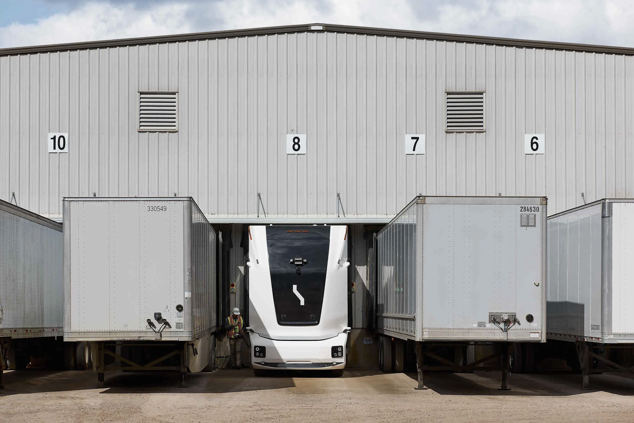 bot truck in dock 8 with other trailers on the sides docked to other docks