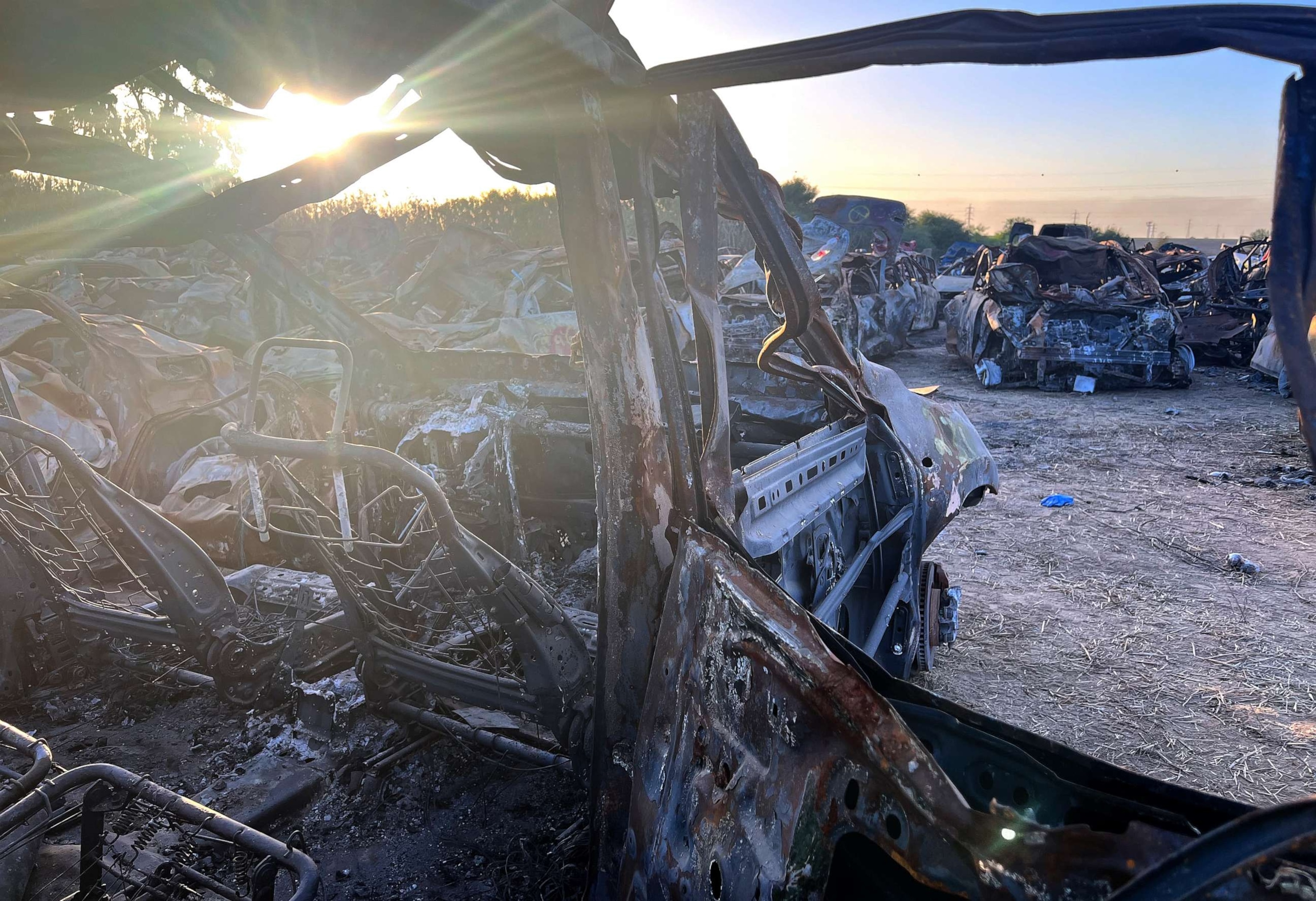 PHOTO: A burnt-out car stands in the setting sun near Netivot, Israel, one of hundreds like it that were recovered from the scene of the deadly Supernova music festival massacre.