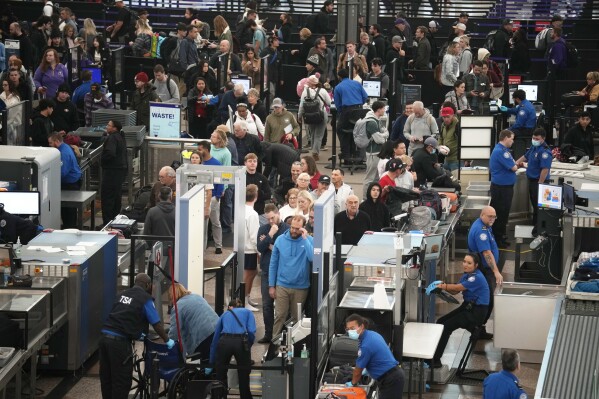 Travellers queue up to pass through the south security checkpoint at Denver International Airport, Monday, Nov. 20, 2023, in Denver. (AP Photo/David Zalubowski)