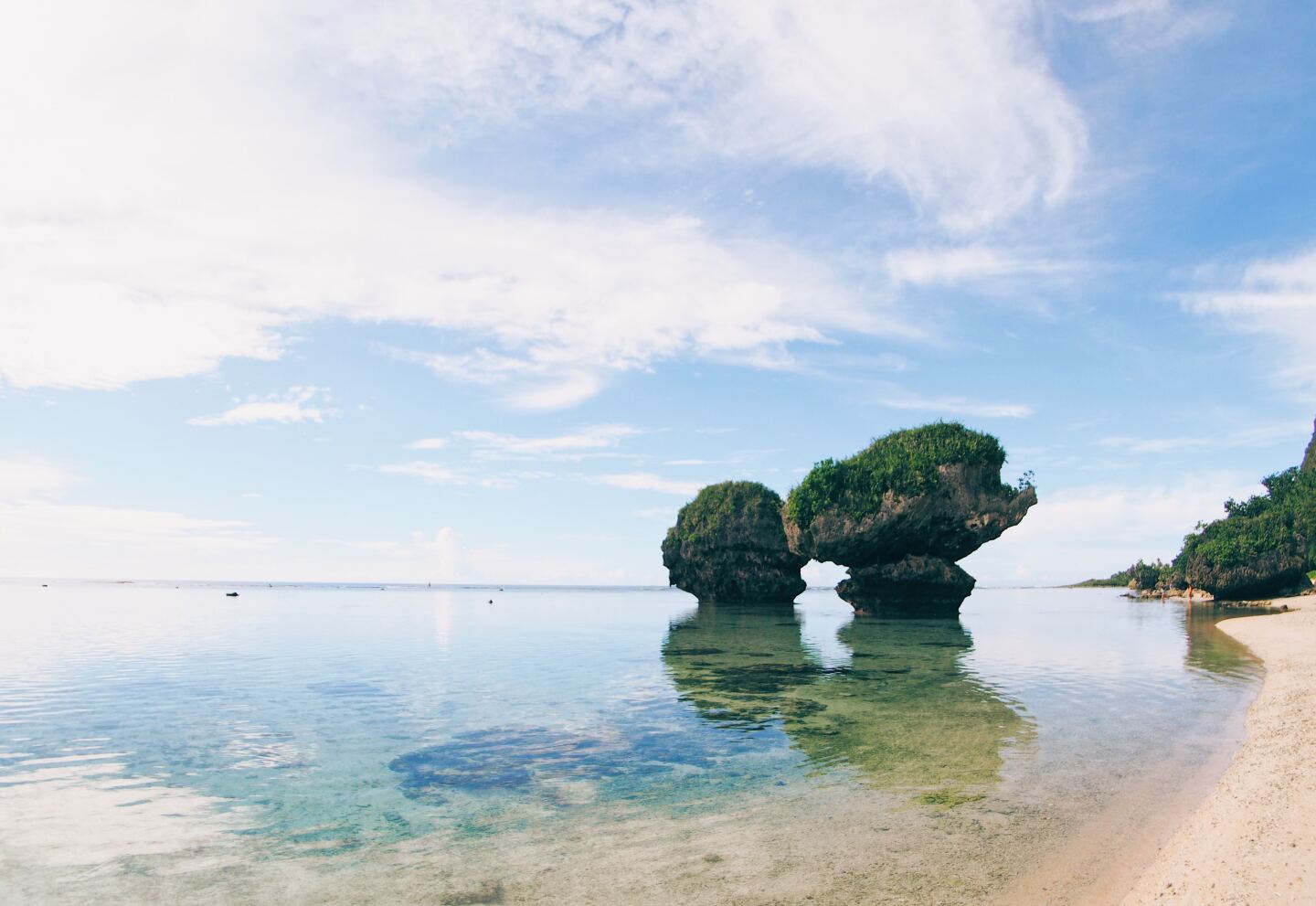 Tanguisson Beach in Guam with two unique rock formations jutting out of the water just feet away from shore