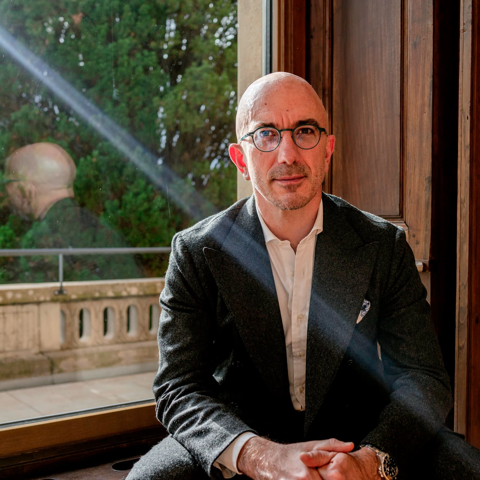 A man sits in front of a window