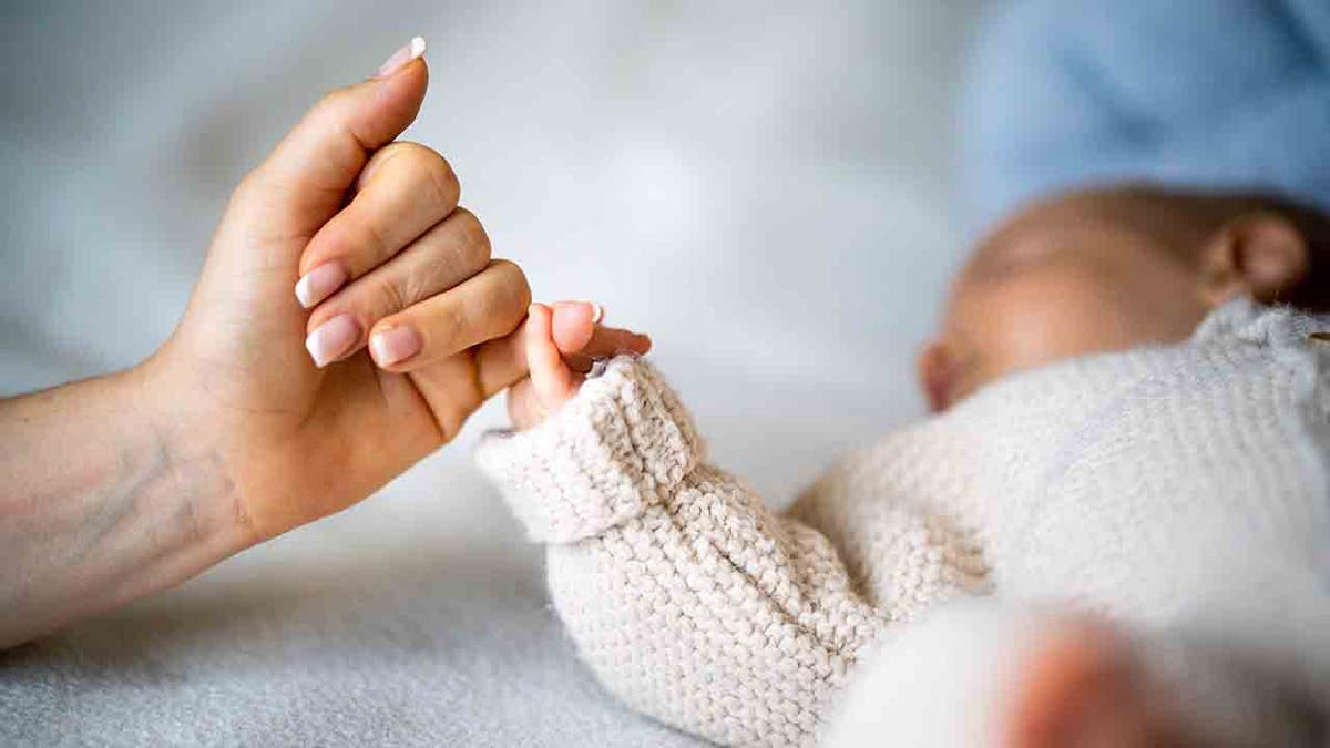 baby holding finger