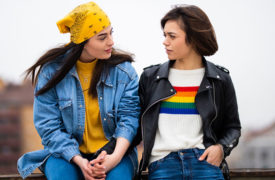 two woman talking rainbow sweater