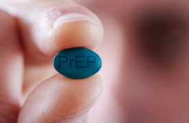 Hand holding blue PrEP pill