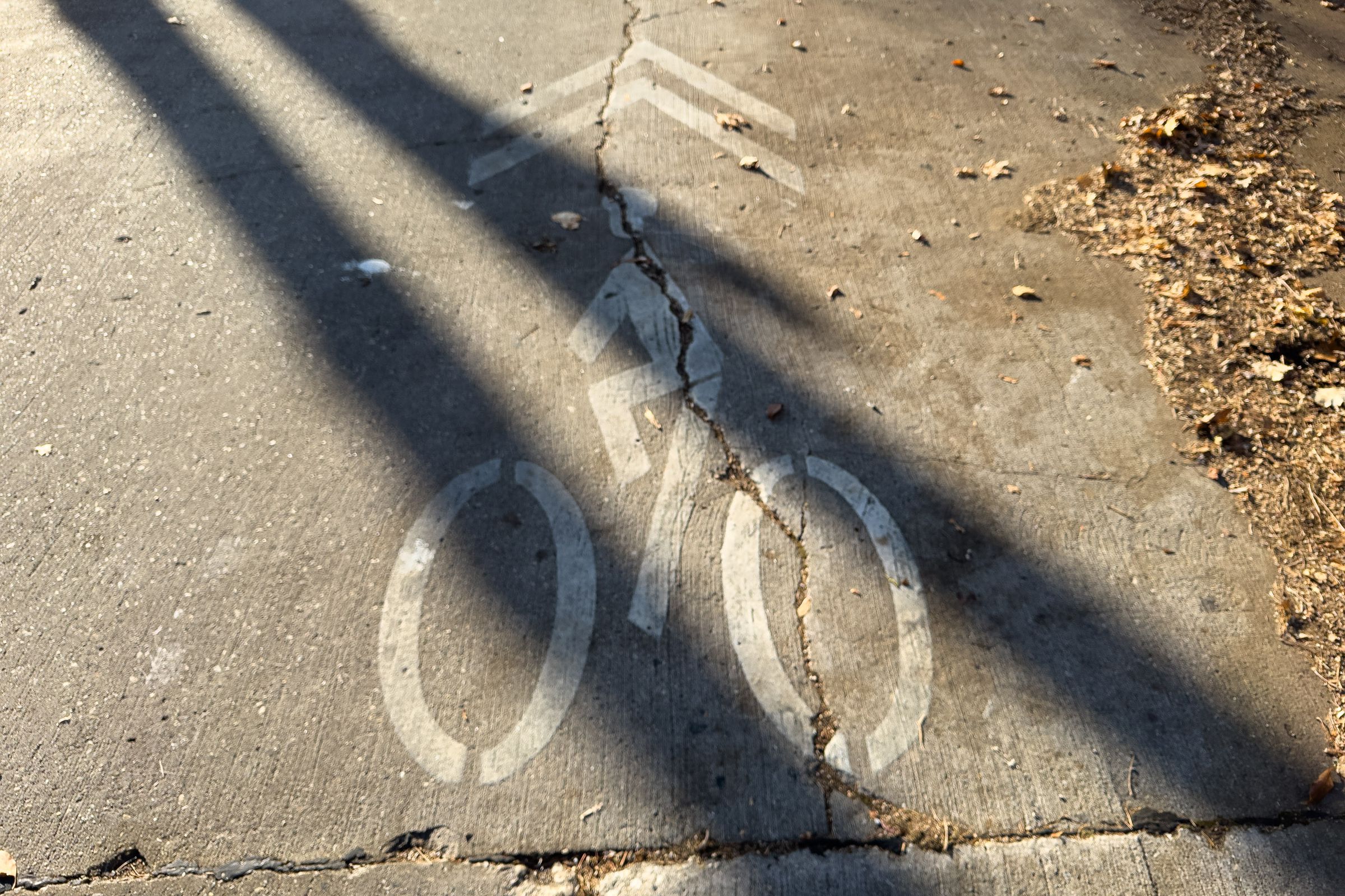 A picture of a sharrow on broken pavement.