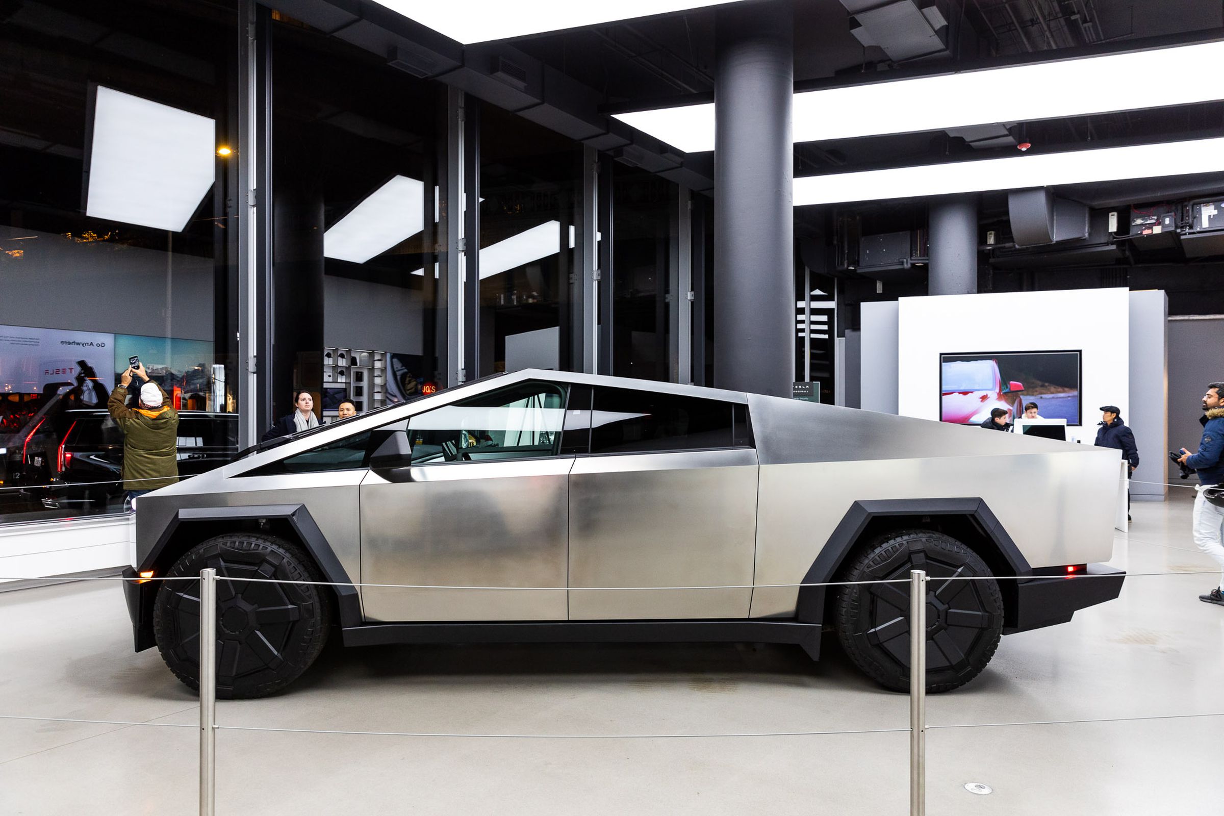 profile view of cybertruck in a tesla showroom