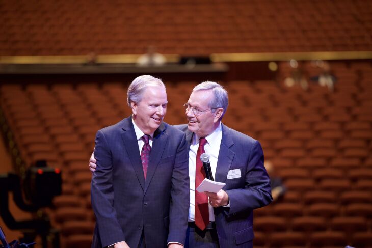 President Michael O. Leavitt and Lloyd Newell stand at the music conductor’s podium in the Conference Center.