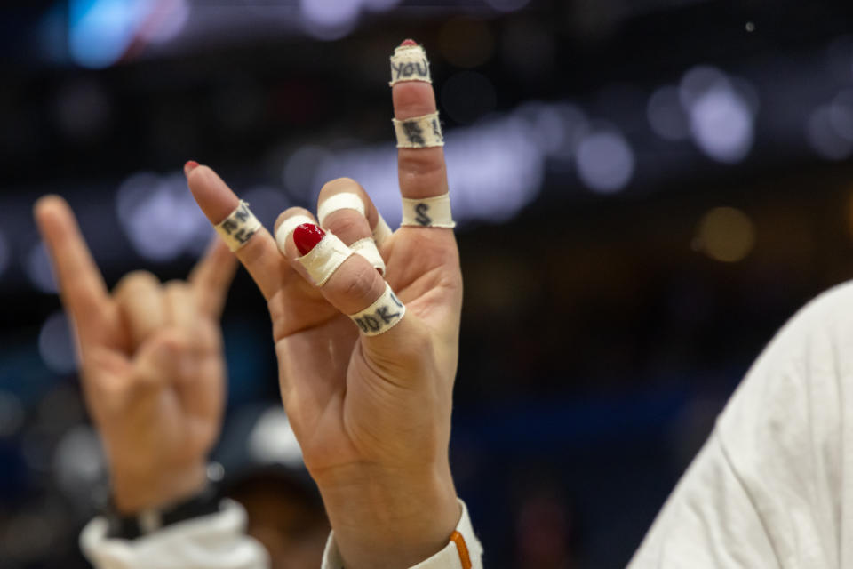 Madisen Skinner holds up her taped fingers in the Hook 'Em horns sign after winning the national championship. (David Buono/Icon Sportswire via Getty Images)