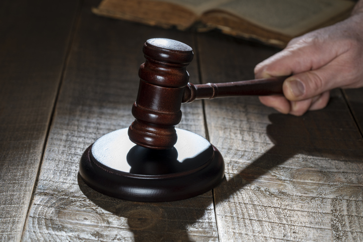 Wooden judge gavel and soundboard on the wooden table background, closeup