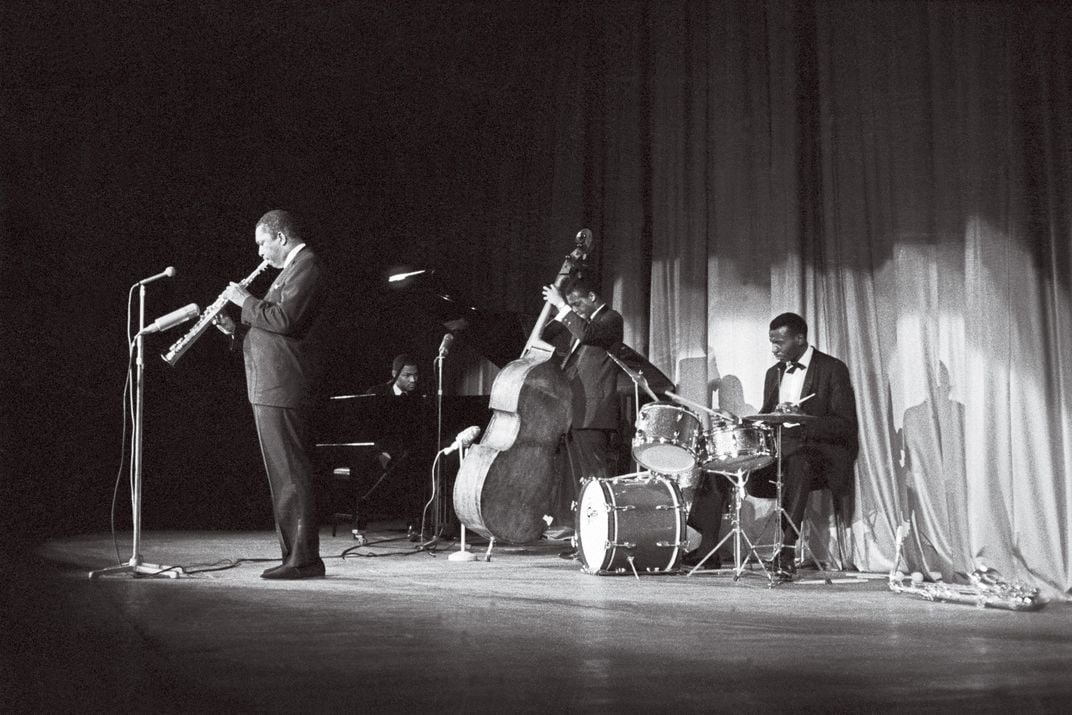 three-piece band playing the clarinet, drums and bass.