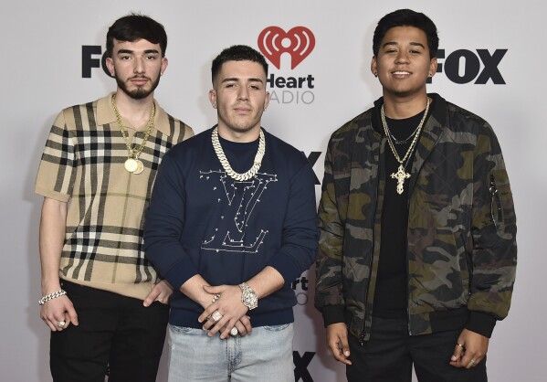 FILE - Brian Tovar, from left, Pedro Tovar and Gabriel Hidalgo of Eslabon Armado arrive at the iHeartRadio Music Awards on Tuesday, March 22, 2022, at the Shrine Auditorium in Los Angeles. Regional Mexican music has become a global phenomenon, topping music charts, breaking streaming records and reaching new audiences as it crosses borders. (Photo by Jordan Strauss/Invision/AP, File)