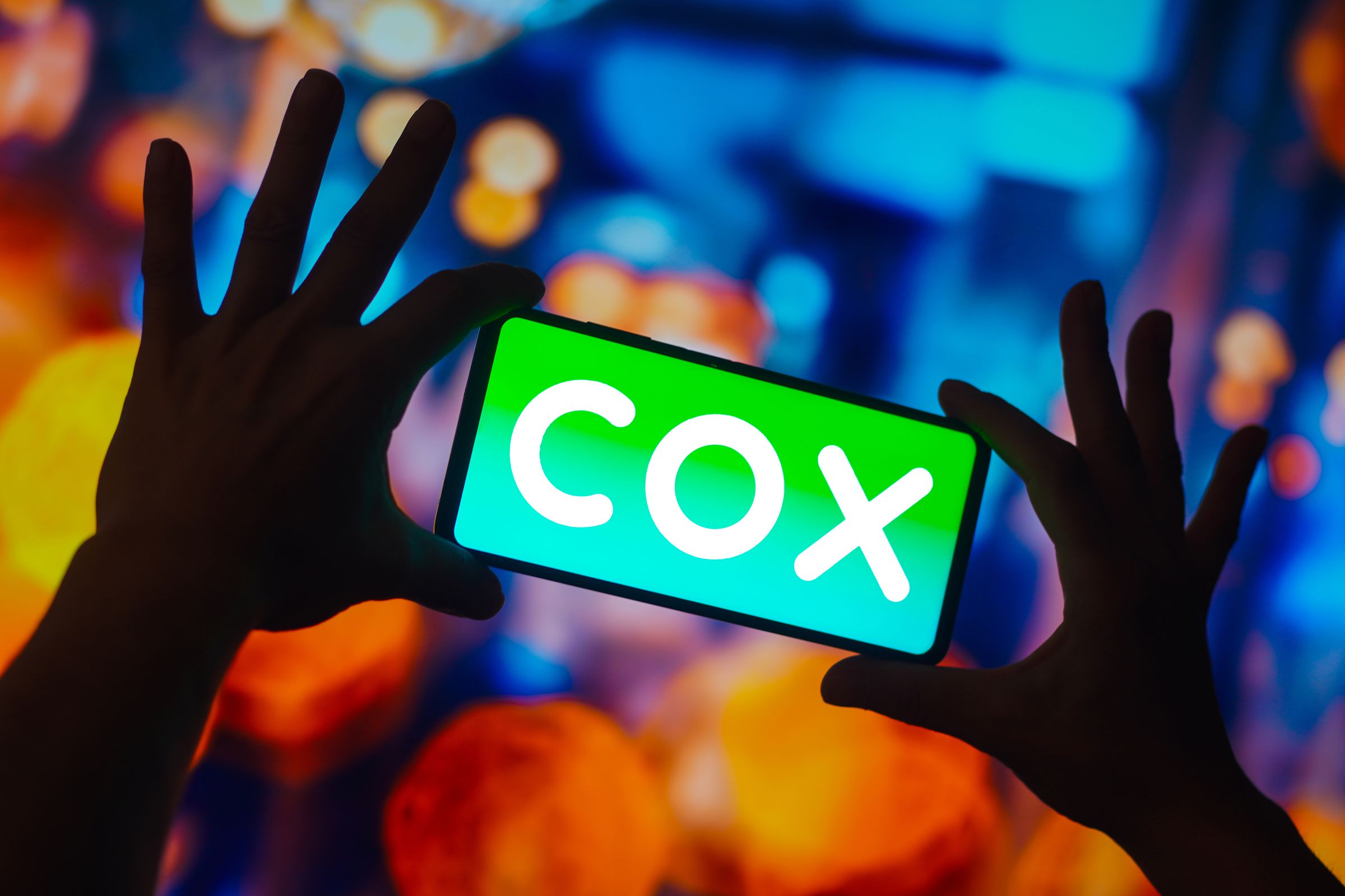 In this photo illustration, the Cox Communications logo is...