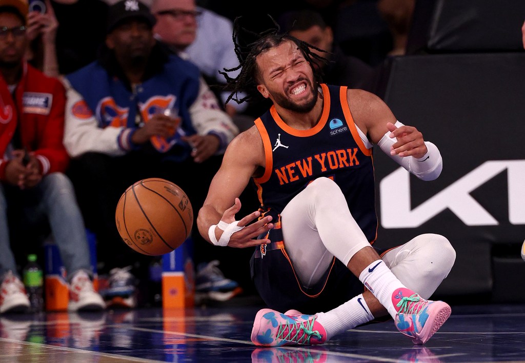 Jalen Brunson holding a basketball while reacting after injuring his ankle during the Knicks vs Grizzlies game in New York City.