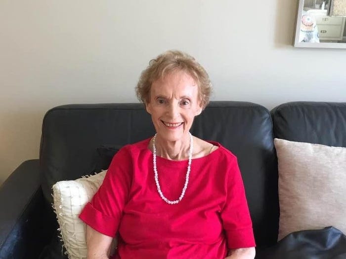 The author's grandmother wearing a red shirt and sitting on a couch.