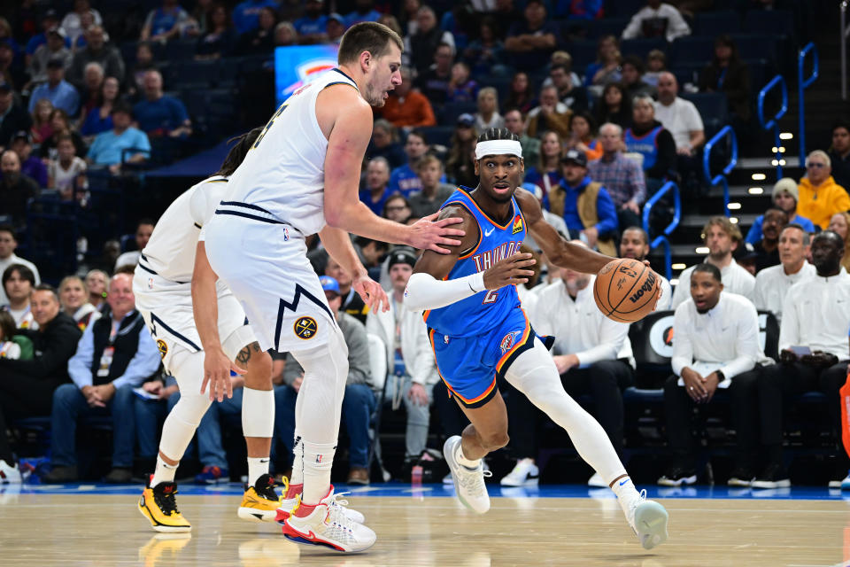 OKLAHOMA CITY, OKLAHOMA - OCTOBER 29: Shai Gilgeous-Alexander #2 of the Oklahoma City Thunder attempts to drive past Nikola Jokic #15 of the Denver Nuggets during the first quarter of a game at Paycom Center on October 29, 2023 in Oklahoma City, Oklahoma. NOTE TO USER: User expressly acknowledges and agrees that, by downloading and or using this photograph, User is consenting to the terms and conditions of the Getty Images License Agreement. (Photo by Joshua Gateley/Getty Images)