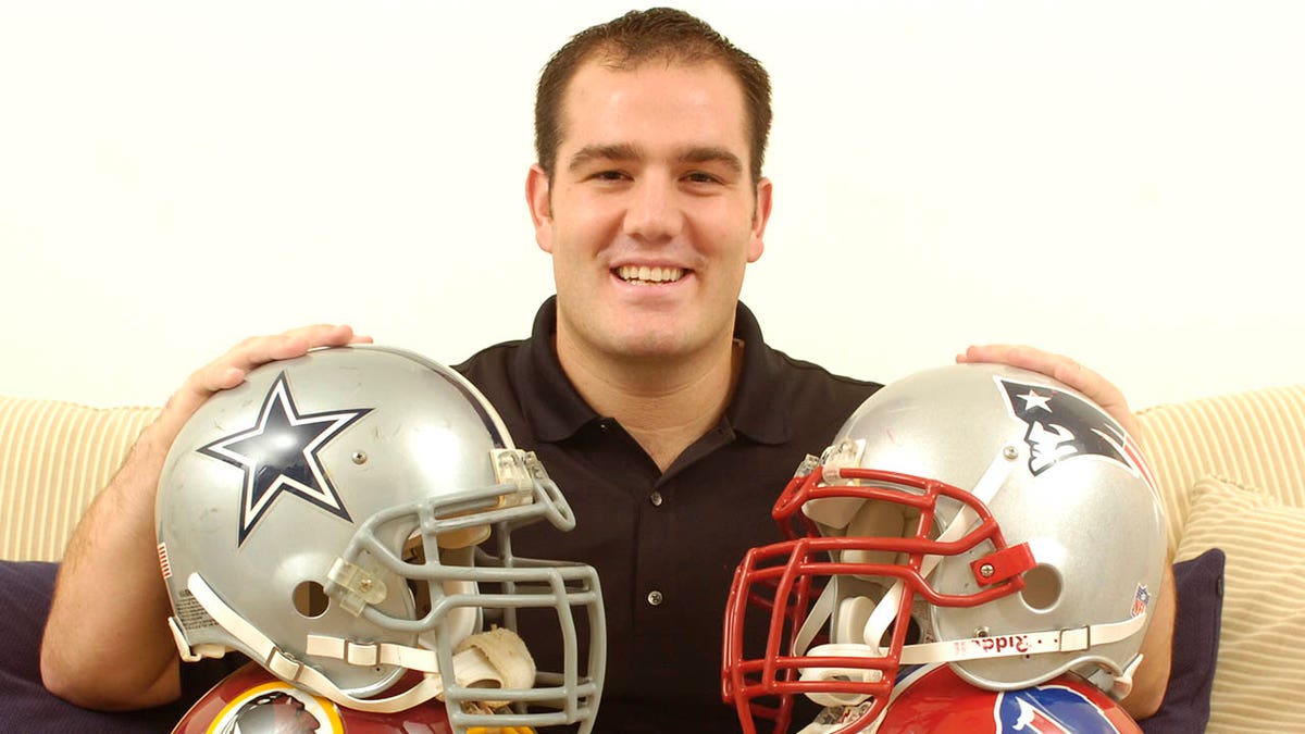 Ross Tucker smiles next to helmets