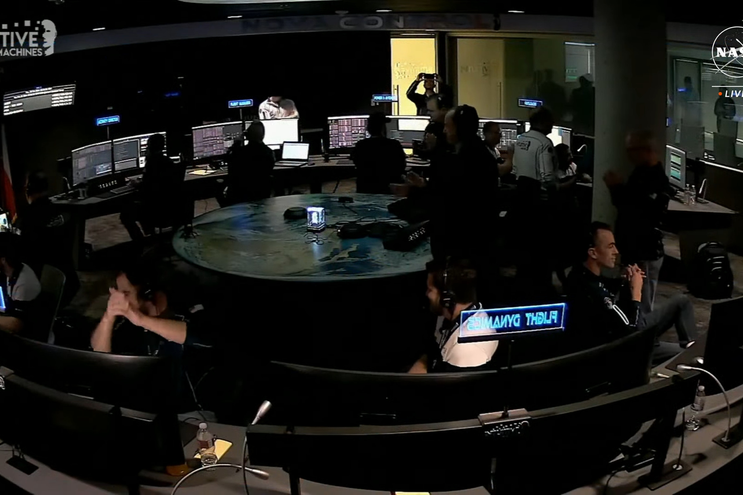 A still frame showing mission control for the Odysseus lunar lander mission with people applauding a successful landing.