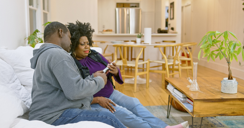 African American Couple Looking at a Pack of Marijuana