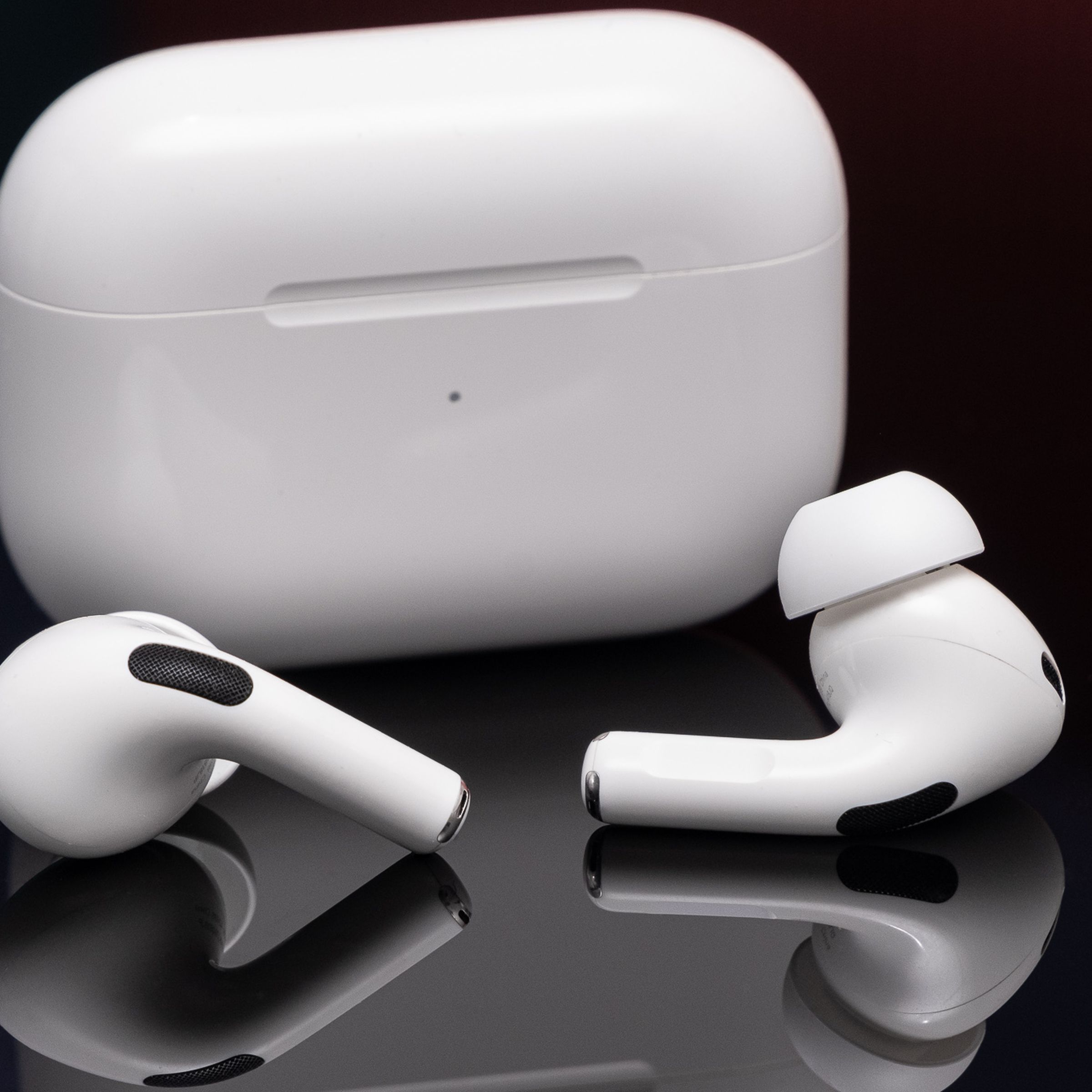 Apple’s second-generation AirPods Pro photographed on a reflective black surface.