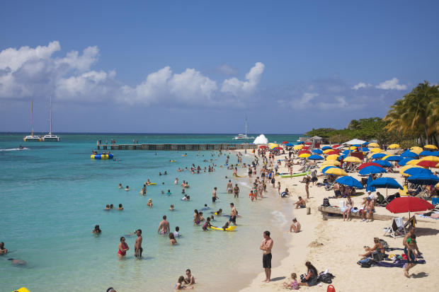 People relax and swim at Doctor's Cave beach 