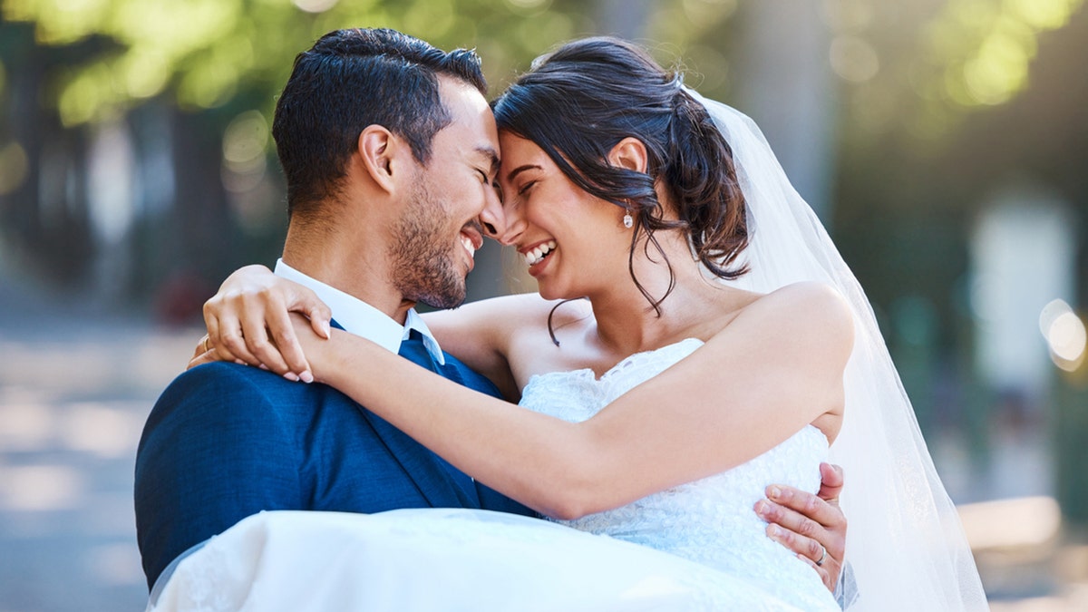 groom carrying bride