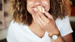 Black woman biting sandwich