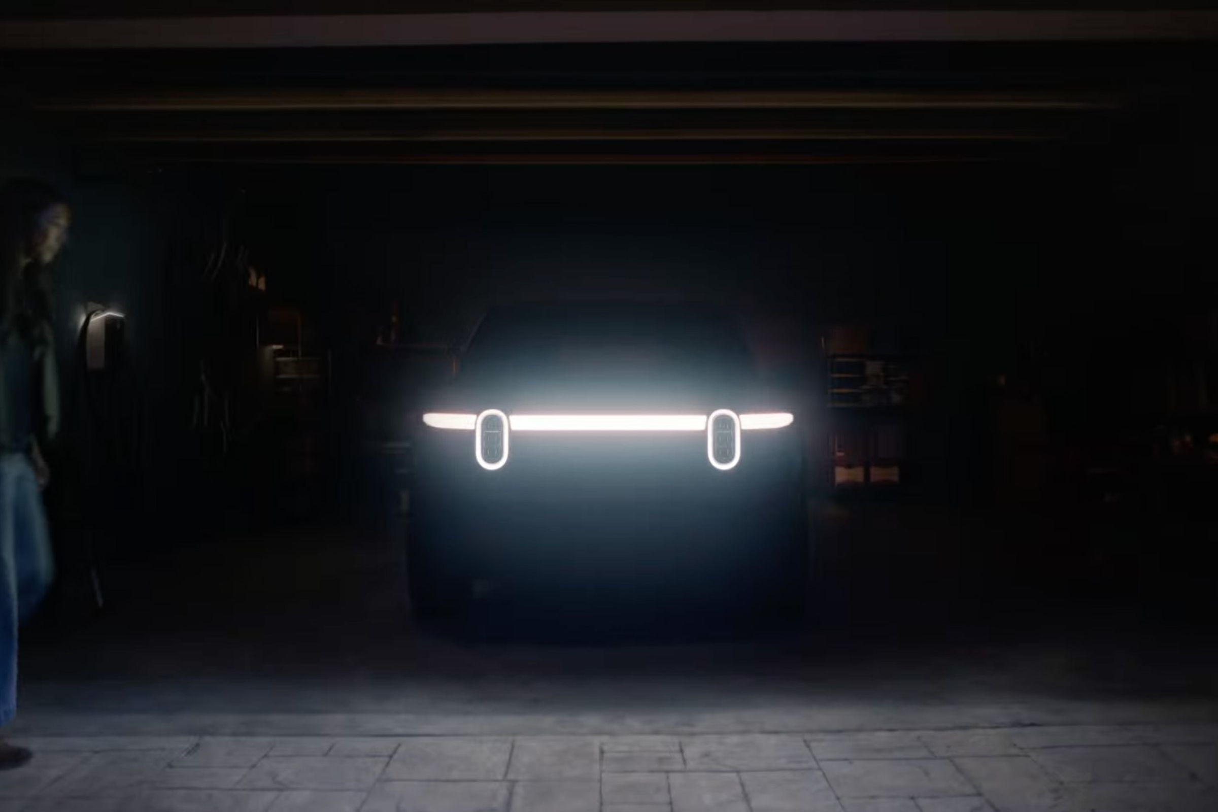 An SUV in a dark garage with headlights illuminated.