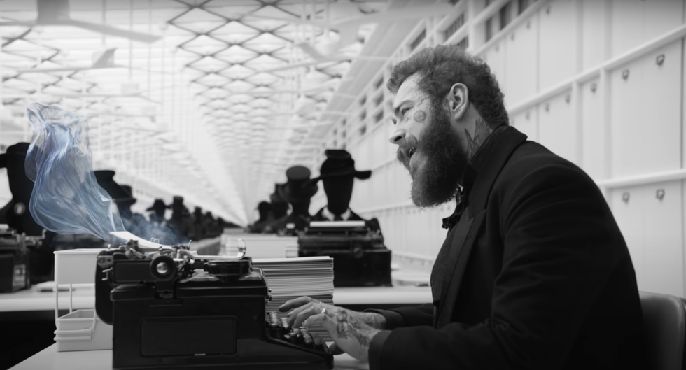 a man sitting at a desk with a machine