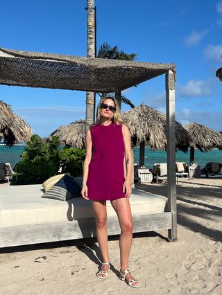 Eliza Huber wearing a magenta Liberowe shift dress with Larroudé flat sandals.