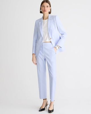 a model wears a light blue pantsuit with black heels