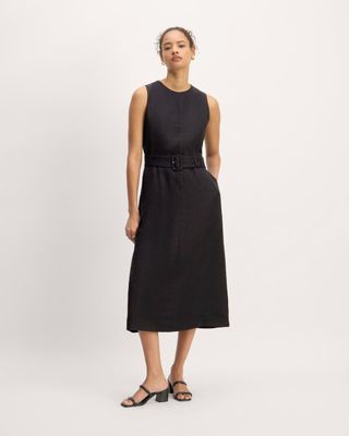 a model wears a black sleeveless midi dress