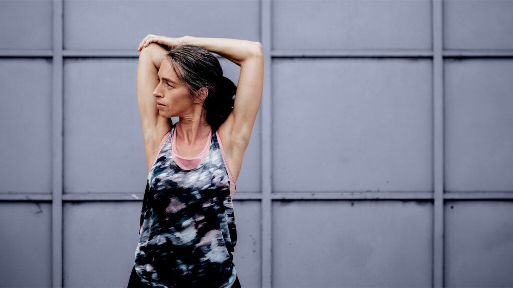 A midlife women stretches her upper body