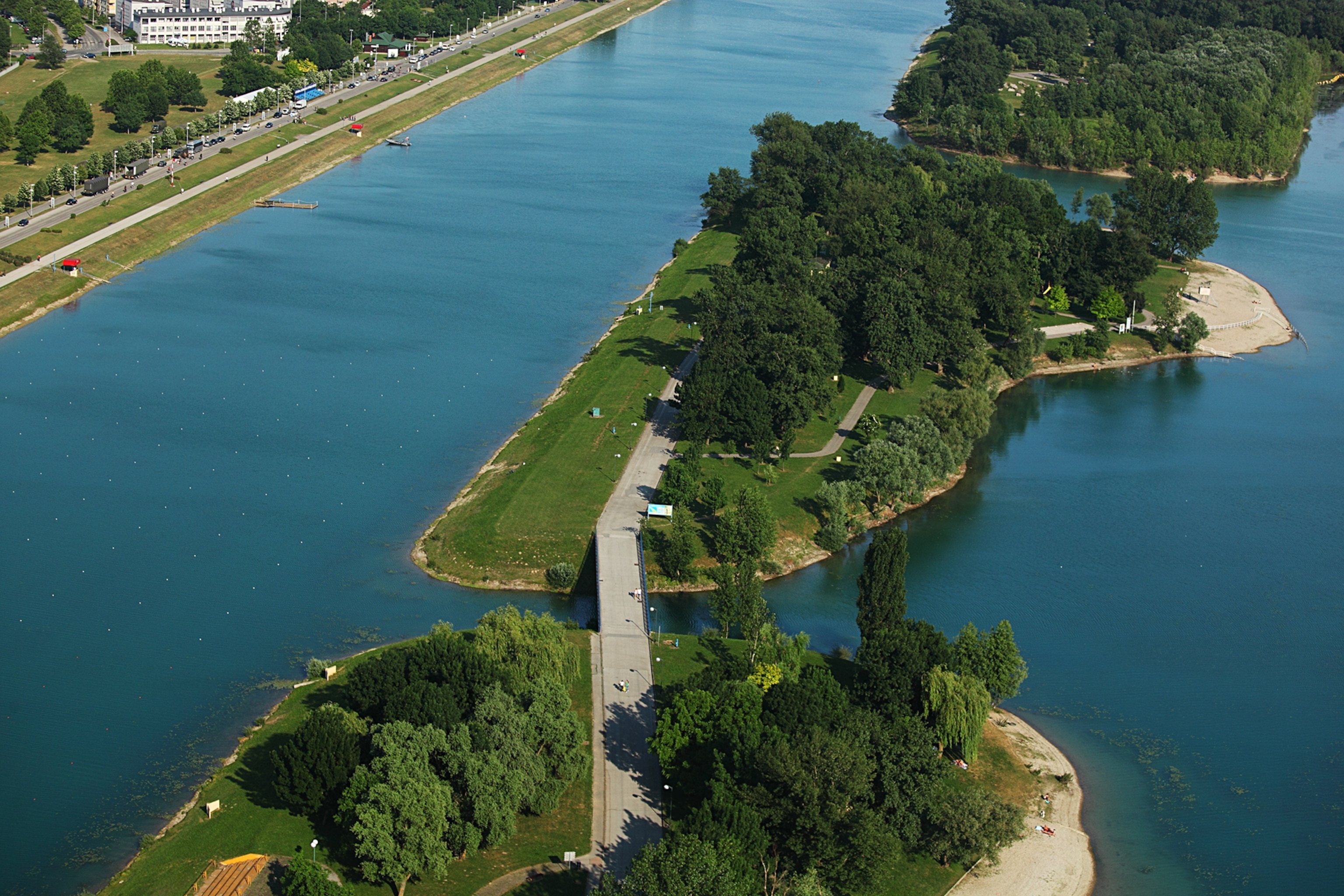 Bird's-eye view of blue Lake Jarun in Zagreb, Croatia, with greenery surrounding.