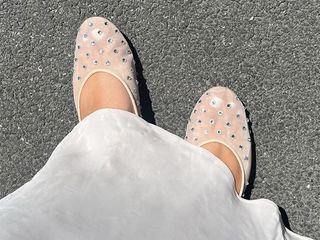 Ana wears mesh flats with white skirt