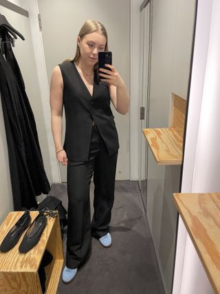 Woman in dressing room wears linen waistcoat and linen trousers