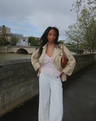 sierra mayhew wearing white pants and a pink blouse in paris